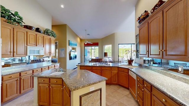 kitchen with a center island, kitchen peninsula, sink, high vaulted ceiling, and dishwashing machine