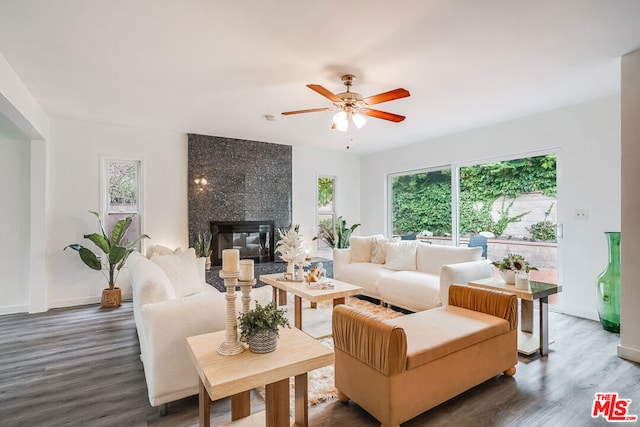 living room featuring dark wood-type flooring, a tiled fireplace, and ceiling fan