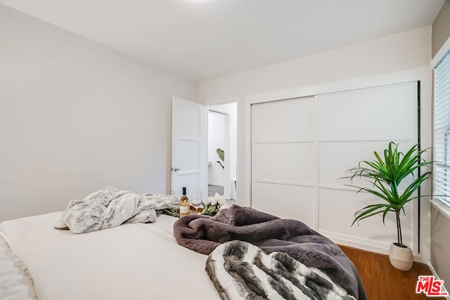 bedroom with hardwood / wood-style flooring and a closet