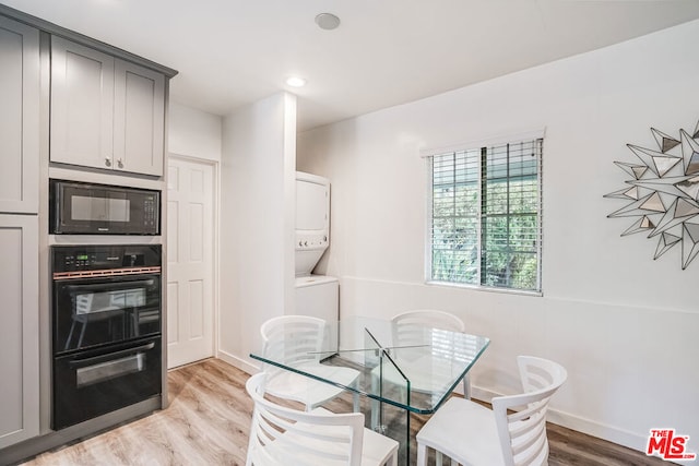 dining room featuring stacked washer and dryer and light wood-type flooring