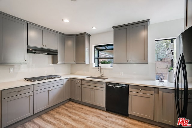 kitchen featuring gray cabinets, sink, light hardwood / wood-style floors, and black appliances