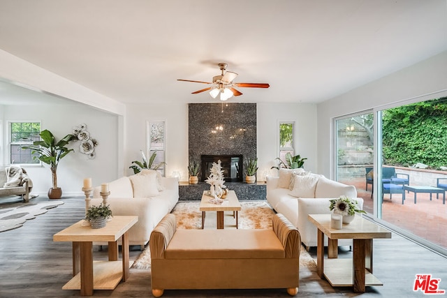 living room featuring hardwood / wood-style flooring, ceiling fan, and a premium fireplace