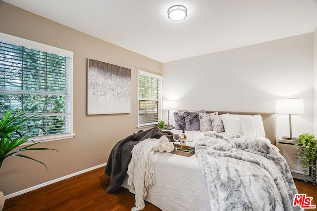 bedroom featuring dark wood-type flooring and multiple windows