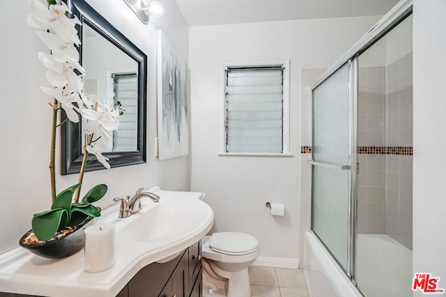 full bathroom featuring enclosed tub / shower combo, toilet, vanity, and tile patterned flooring