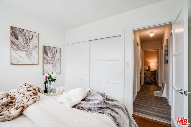 bedroom with a closet and dark hardwood / wood-style flooring