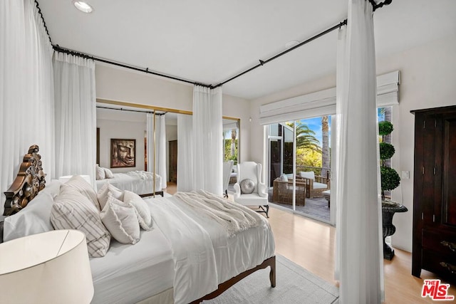 bedroom with light wood-type flooring, a closet, and access to exterior