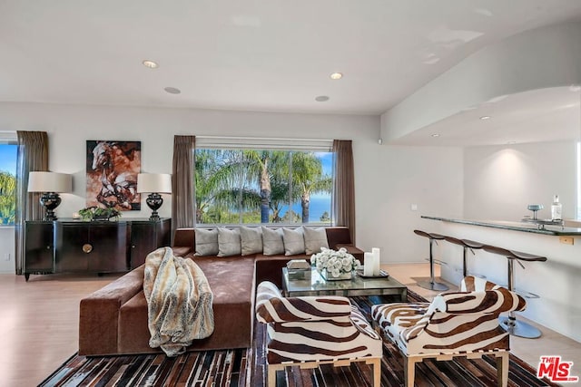 living room with light wood-type flooring and vaulted ceiling