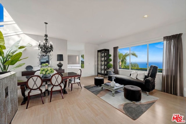 living room featuring a water view, a notable chandelier, and light hardwood / wood-style floors