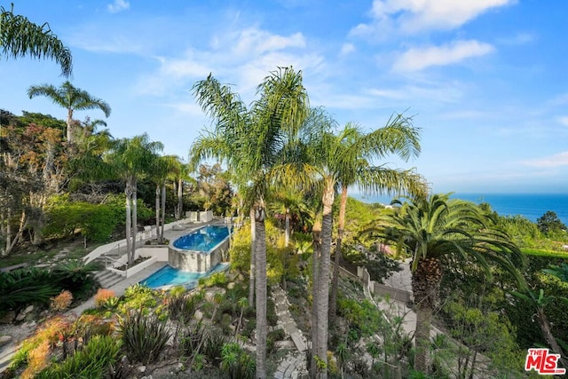 view of swimming pool featuring a water view and a patio