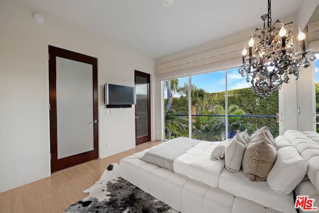 bedroom with a chandelier and light hardwood / wood-style floors