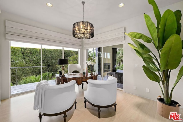 sitting room featuring a healthy amount of sunlight, light wood-type flooring, and a chandelier