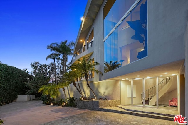 property exterior at dusk featuring a patio