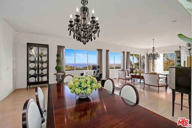 dining space featuring a notable chandelier and light hardwood / wood-style floors