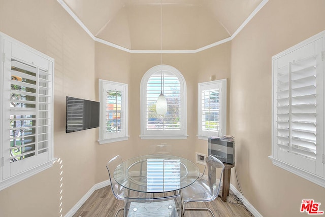 dining room with lofted ceiling, crown molding, and hardwood / wood-style floors