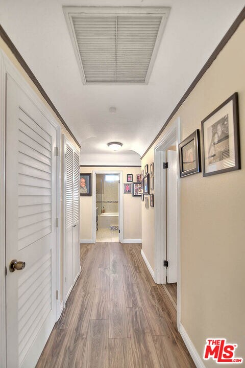 hall featuring ornamental molding and hardwood / wood-style floors