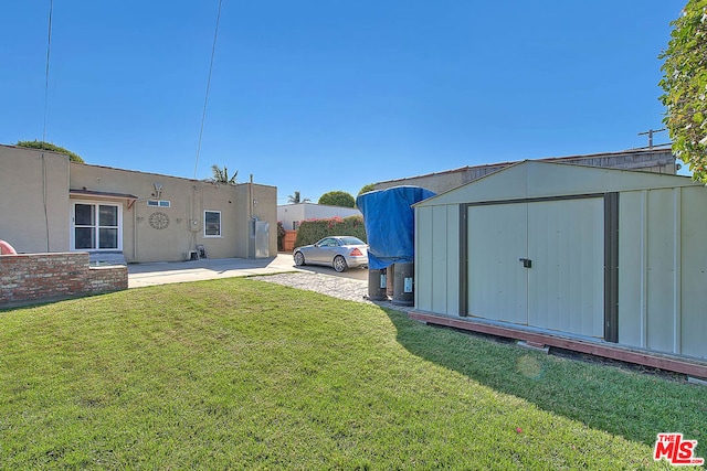 view of yard featuring a storage unit and a patio