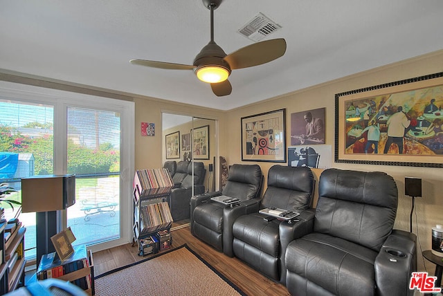 cinema featuring ceiling fan, wood-type flooring, and crown molding