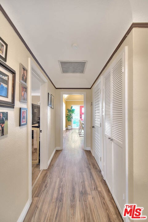 hall featuring ornamental molding and hardwood / wood-style flooring