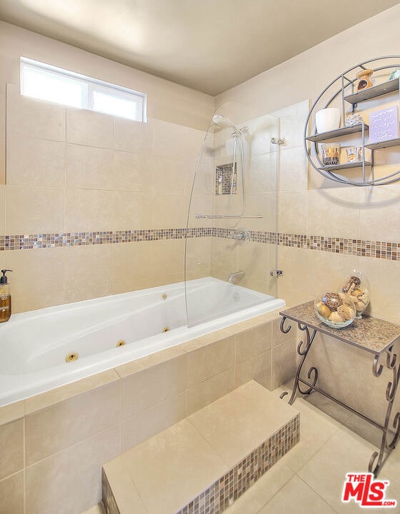 bathroom with tile patterned flooring and tiled shower / bath