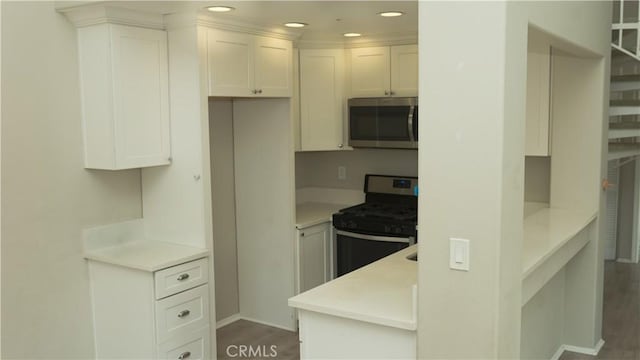 kitchen featuring white cabinets, dark hardwood / wood-style flooring, and stainless steel appliances