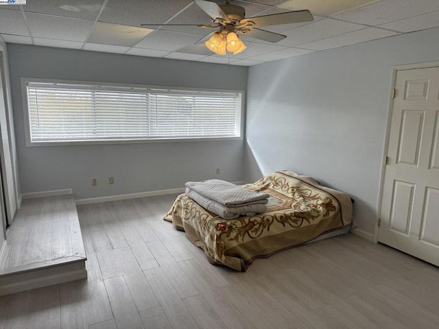 bedroom with ceiling fan, hardwood / wood-style flooring, and a paneled ceiling