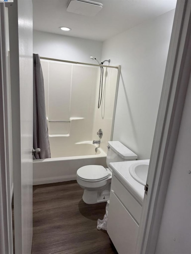 full bathroom with wood-type flooring, toilet, vanity, and shower / bathtub combination with curtain