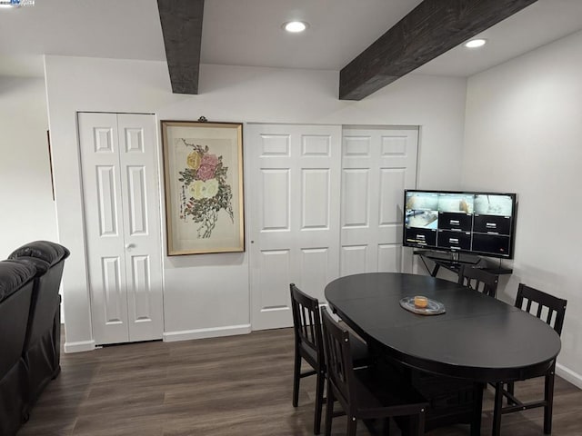 dining space featuring beam ceiling and dark wood-type flooring