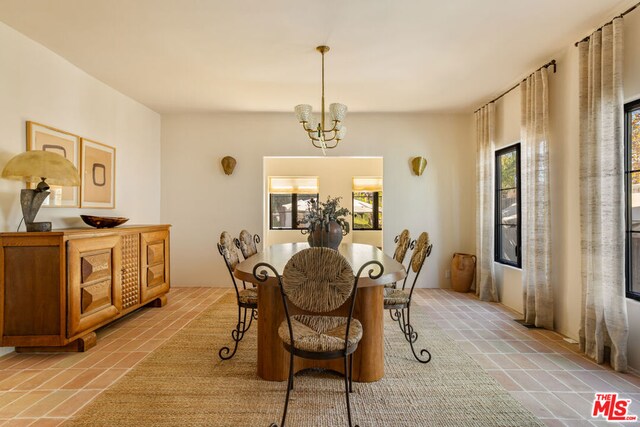 dining space with light tile patterned floors and a chandelier