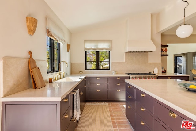 kitchen featuring lofted ceiling, sink, hanging light fixtures, stainless steel gas cooktop, and light tile patterned flooring