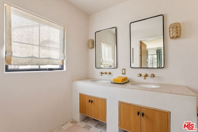 bathroom with a wealth of natural light, tile patterned floors, and vanity