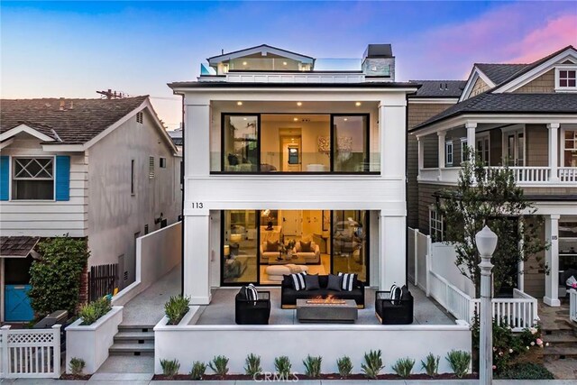 back house at dusk with an outdoor hangout area