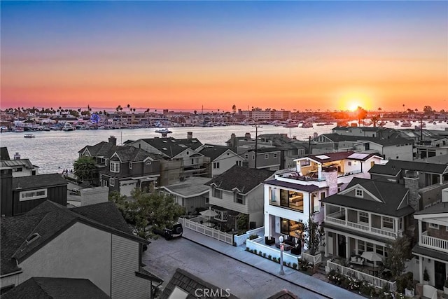 aerial view at dusk featuring a water view