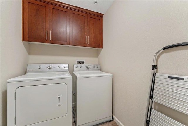 laundry room featuring independent washer and dryer and cabinets