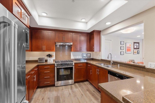 kitchen featuring sink, light wood-type flooring, kitchen peninsula, stone counters, and stainless steel appliances