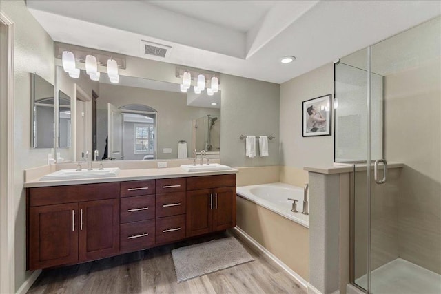 bathroom with shower with separate bathtub, wood-type flooring, and vanity