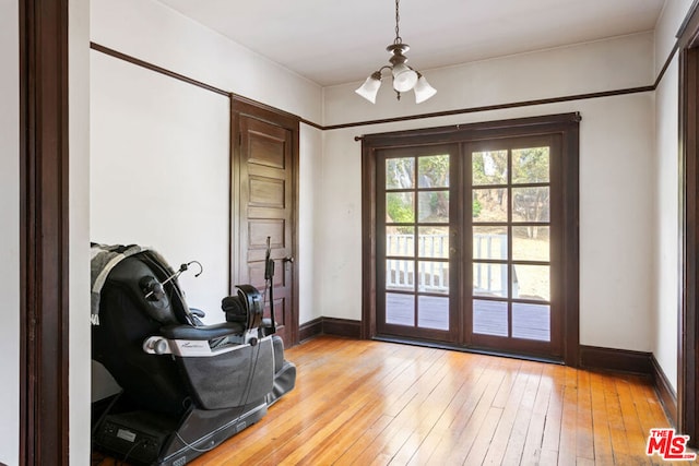 doorway with light hardwood / wood-style floors and a chandelier