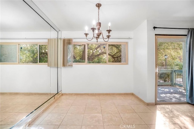 unfurnished dining area with a healthy amount of sunlight, a notable chandelier, and light tile patterned flooring