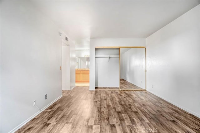 unfurnished bedroom featuring hardwood / wood-style flooring and a closet