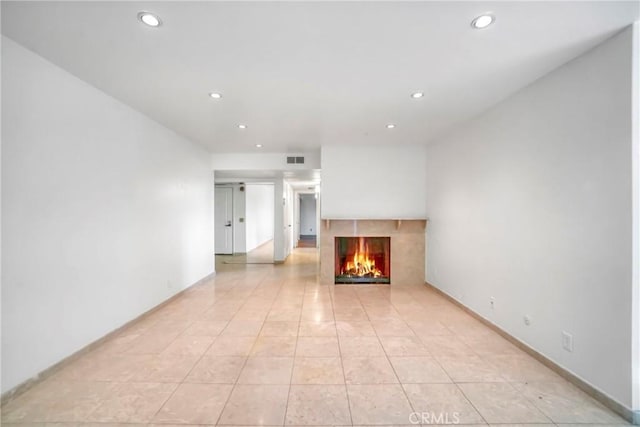 unfurnished living room featuring light tile patterned floors and a fireplace