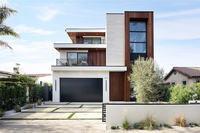 contemporary house featuring a garage and a balcony