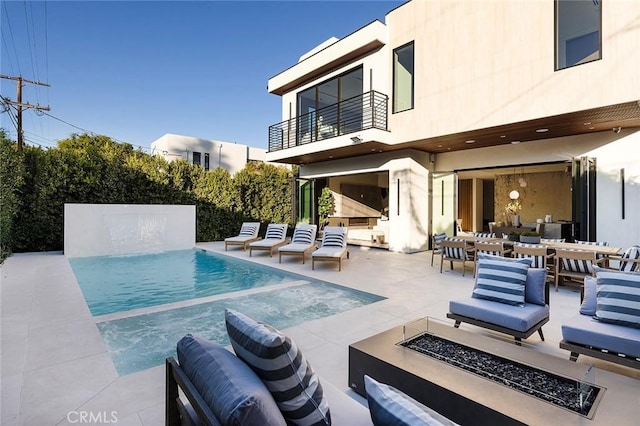 view of pool featuring an outdoor living space with a fire pit and a patio