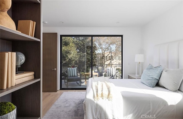 bedroom with access to exterior and light hardwood / wood-style floors