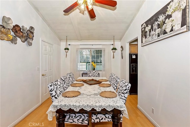 dining area with ceiling fan, vaulted ceiling with beams, wood ceiling, and light hardwood / wood-style flooring