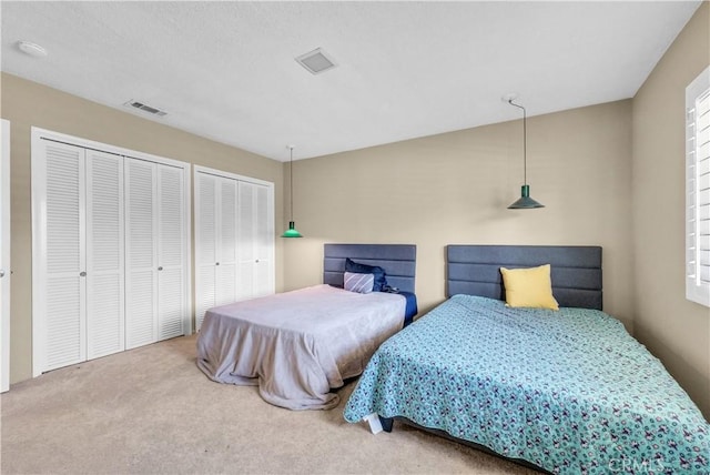 carpeted bedroom with multiple closets