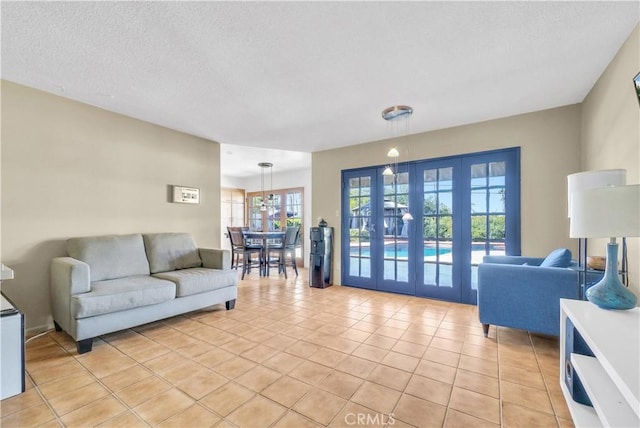 tiled living room with french doors and a textured ceiling