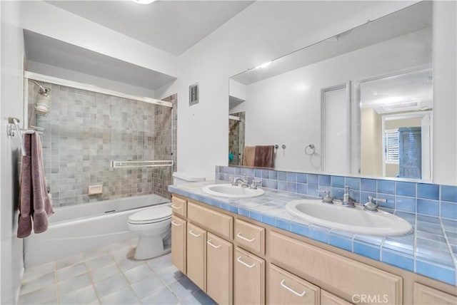 full bathroom with vanity, toilet, bath / shower combo with glass door, and backsplash