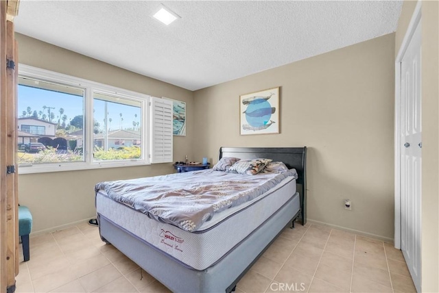 tiled bedroom featuring a textured ceiling and a closet