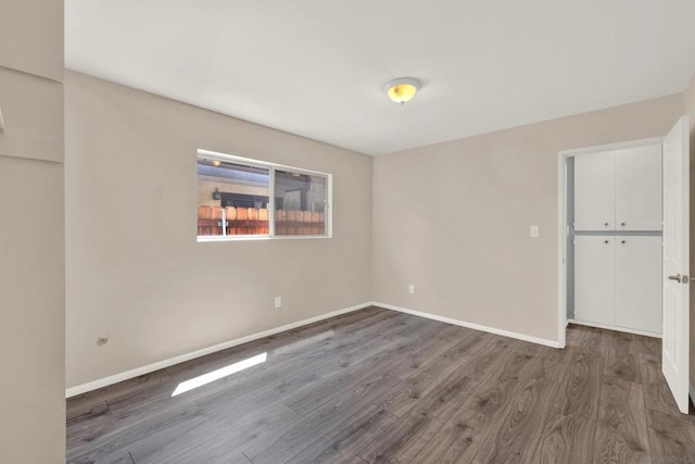 unfurnished room with dark wood-type flooring