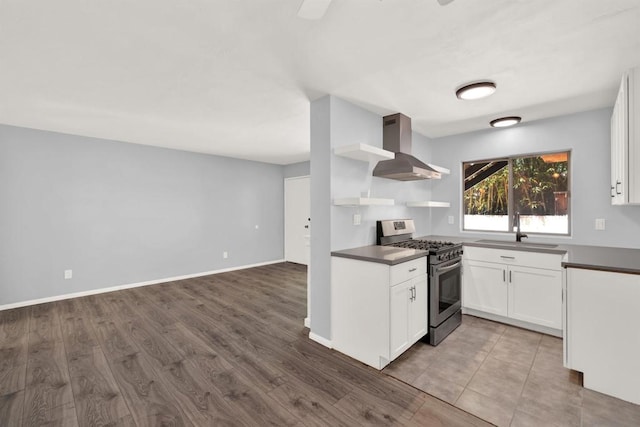 kitchen with exhaust hood, gas stove, wood-type flooring, white cabinetry, and sink