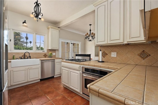 4485 Myrtle Ave, Long Beach, CA 90807 - kitchen featuring tile counters, appliances with stainless steel finishes, an inviting chandelier, pendant lighting, and a sink